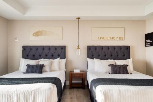 two beds sitting next to each other in a room at Eazy Rio by ULIV in Tijuana