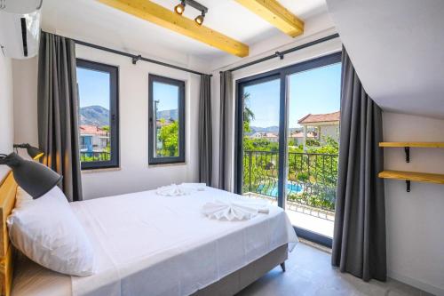 a bedroom with a bed and a large window at Meva Luxury Apartments in Muğla
