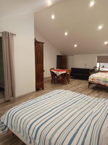 a bedroom with a bed and a table in it at studio3 spacieux 1à4 pers in Marboz