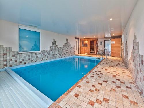 a swimming pool with blue water in a house at Haus Eifelsonne in Ramscheid