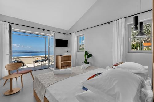 a bedroom with a bed and a view of the ocean at Villa Laurante in Tučepi