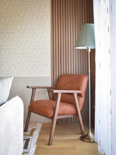 a chair sitting next to a lamp in a bedroom at Montewave Studio Apartment in Boreti