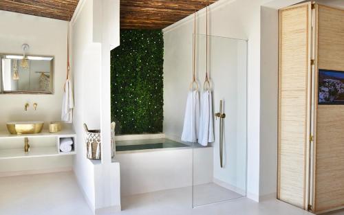 a bathroom with a glass shower and a sink at Elefthia Syros - Luxury Houses & Suites in Megas Gialos - Nites