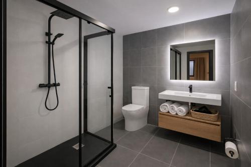 a bathroom with a shower and a toilet and a sink at Nova Suites Viveiro in Viveiro