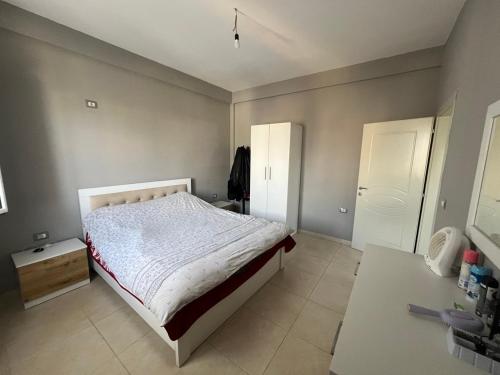 a bedroom with a bed with a white bedspread at Garden Vila Apartment in Kamëz