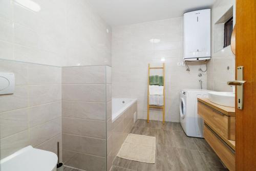 a bathroom with a sink and a toilet and a tub at Apartment Renata in Njivice