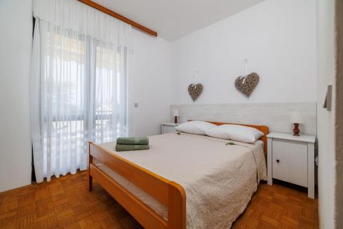 a bedroom with a bed and a large window at Apartment Renata in Njivice