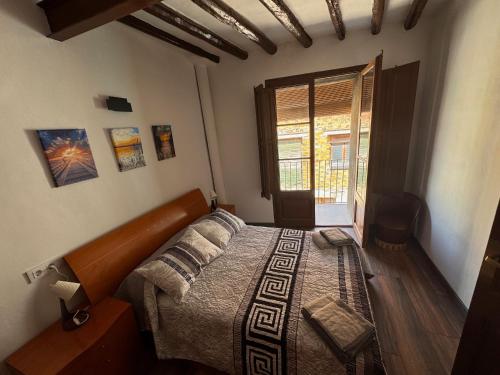 a bedroom with a bed in a room with a window at Cal Padrí in Caseras