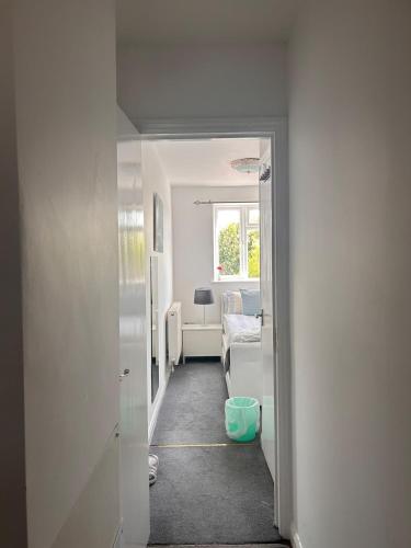 a hallway with a room with a bed and a window at Comfortable en-suite one bed room studio in Oxford