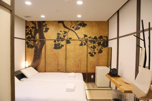 a bedroom with two beds and a wall with a painting at oyasumi hotel 道頓堀 Zero-pressure mattress in Osaka