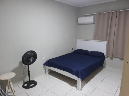a bedroom with a bed with blue sheets and a fan at Casa confortável a 3km do centro in Petrolina