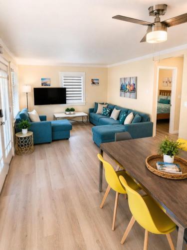 a living room with a blue couch and a table at CasaViva Sky - 3BR 1BA Sleeps 10 - Rooftop City Views, Firepit & Bunk Room - Near Zoo & Beaches in San Diego