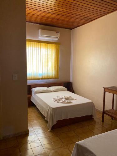 a bedroom with two beds and a window and a bedvisor at Hotel Bela Vista in Costa Marques