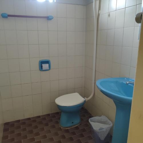 a bathroom with a blue toilet and a sink at Hotel Bela Vista in Costa Marques