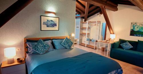a bedroom with a blue bed and a couch at Cascina Silene in Castelmarte