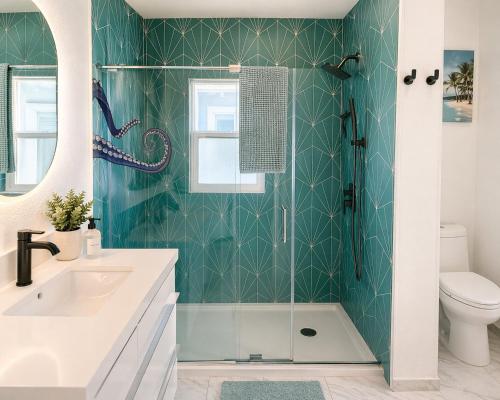 a bathroom with a green tiled wall at CasaViva Sky - 3BR 1BA Sleeps 10 - Rooftop City Views, Firepit & Bunk Room - Near Zoo & Beaches in San Diego