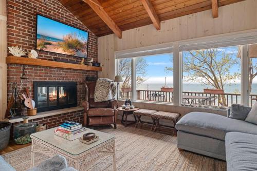 a living room with a brick wall with a tv at Gasthaus Fox by Juniper Holiday + Home in Bridgman