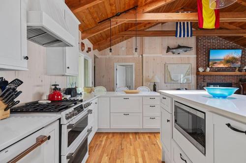 a kitchen with white appliances and wooden ceilings at Gasthaus Fox by Juniper Holiday + Home in Bridgman