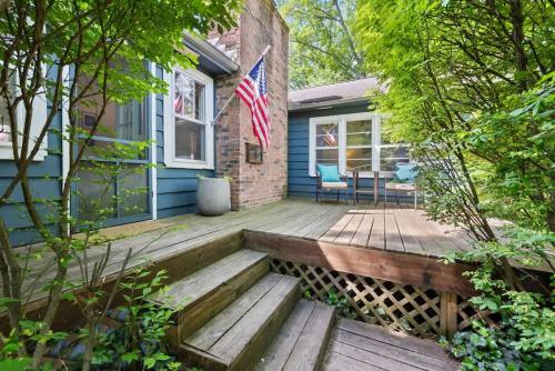 a home with a wooden porch with an american flag at Nan's Escape by Juniper Holiday + Home in Union Pier