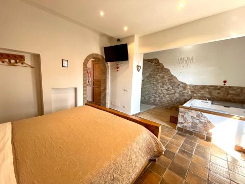 a bedroom with a bed and a stone wall at “La Casetta nel Borgo” in Cerveteri