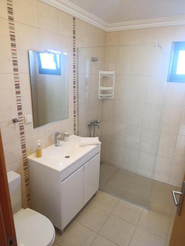 a white bathroom with a sink and a shower at Casa de Campo in Caniço