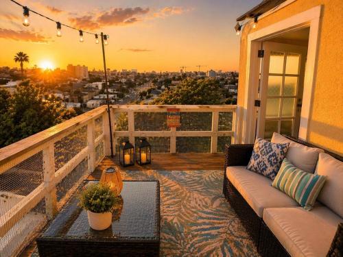 a couch on a balcony with a view of a city at CasaViva Sky - 3BR 1BA Sleeps 10 - Rooftop City Views, Firepit & Bunk Room - Near Zoo & Beaches in San Diego