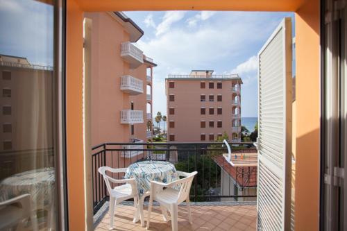 a balcony with a table and chairs on a balcony at Hotel Nello in Marina di Andora