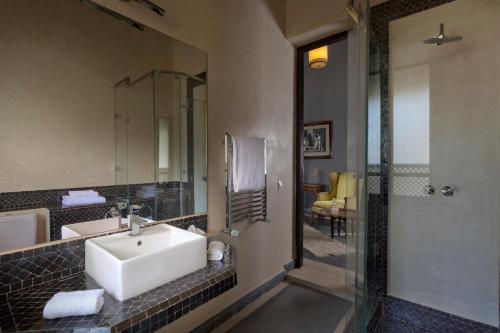 a bathroom with a sink and a mirror and a shower at Riad Palais Bahia Fes in Fès