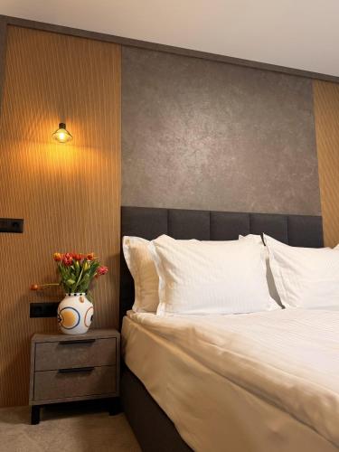 a bedroom with a bed and a vase of flowers on a nightstand at Vip Stay in Gotse Delchev