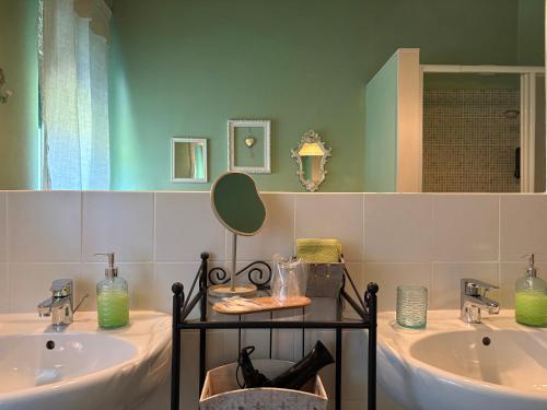 a bathroom with two sinks and a mirror at Bed & Breakfast Cascina Beatrice in Rodello