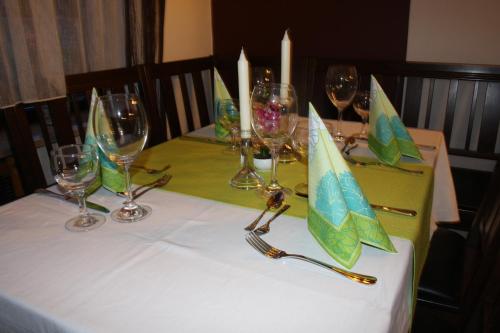 a table with wine glasses and candles on it at Pension Kirchenwirt in Niederaichbach