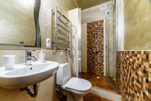 a bathroom with a toilet and a sink and a shower at Zdesj Zhivet Schastje in Lviv