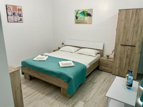 a bedroom with a bed with two towels on it at Solemar Boutique in Eforie Sud