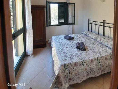 a bedroom with a bed with shoes on it at Agriturismo La Tuva in Padru