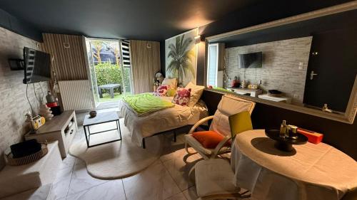 a living room with a bed and a table at Le Must - Chambre double entre Paris et Disney in Livry-Gargan