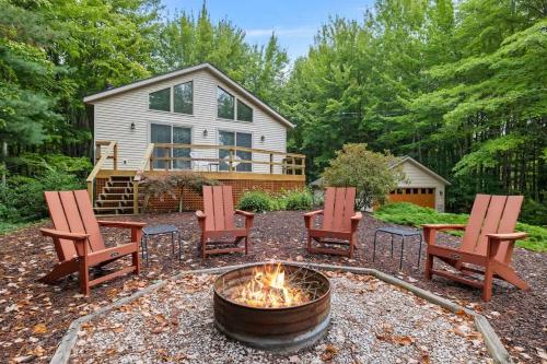 a fire pit with chairs and a house in the background at The Coyote by Juniper Holiday + Home in Saugatuck