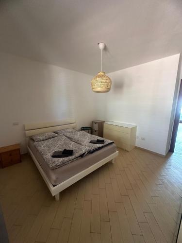 a bedroom with a bed and a chandelier at Hilltop Apartment in Castelsardo