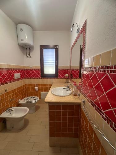 a bathroom with two sinks and a toilet at Hilltop Apartment in Castelsardo