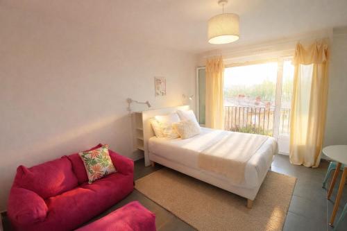 a bedroom with a bed and a red couch at Le Candy- Appartement de charme à Digoin in Digoin