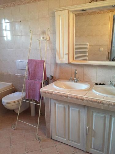 a bathroom with two sinks and a purple towel at Viktória Inn Tihany in Tihany