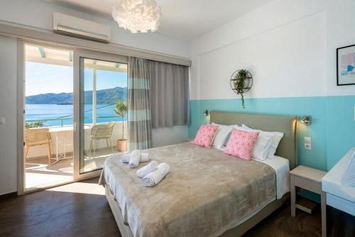 a bedroom with a bed with a view of the ocean at Theodora Rooms in Poros
