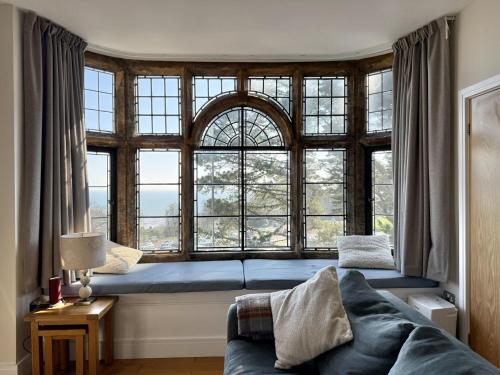a living room with a couch and a large window at 4 Coram Tower in Lyme Regis