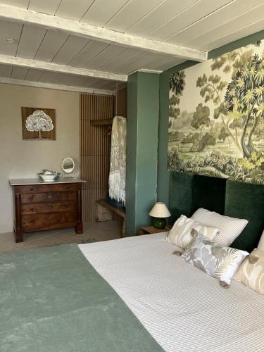 a bedroom with a bed with a painting on the wall at Ô Vieux Moulin in Duras