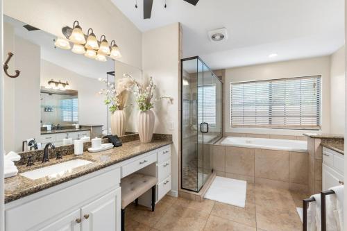 a bathroom with two sinks and a shower and a tub at Glendale Paradise - Pool - Pickleball - Putt-Putt in Glendale
