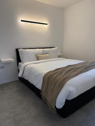 a bedroom with a large bed with white sheets at Coastal Escape in Burtonport