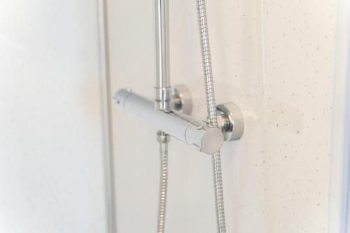 a shower door with a metal handle on a white wall at Coastal Escape in Burtonport