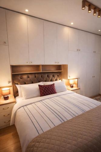a bedroom with a large bed with white cabinets at Koviljača apartman Demetrios in Banja Koviljača