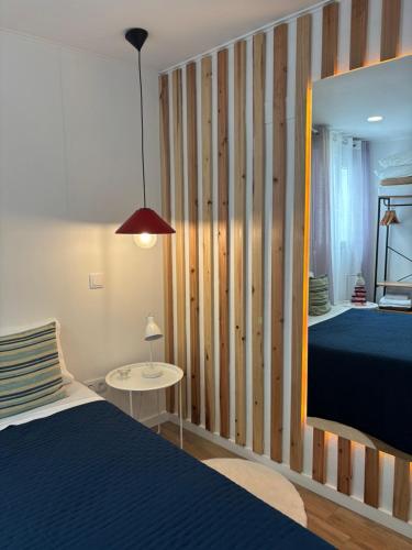 a bedroom with a blue bed and a mirror at Casa do Aviador in Relva