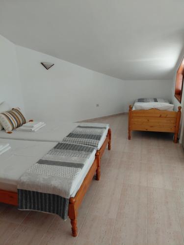 a room with two beds and a bench in it at Студиа Мансарда Ненови in Pomorie