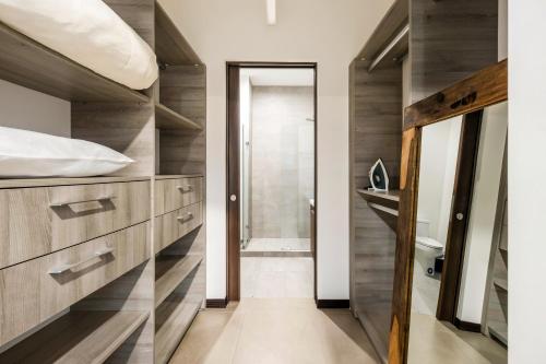 a bathroom with wooden cabinets and a walk in shower at Urban Flats Studios by Corporate Stays in San José